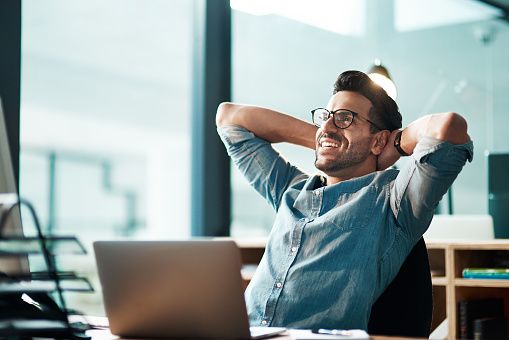 Shot of a young businessman taking a break at his desk in a modern office