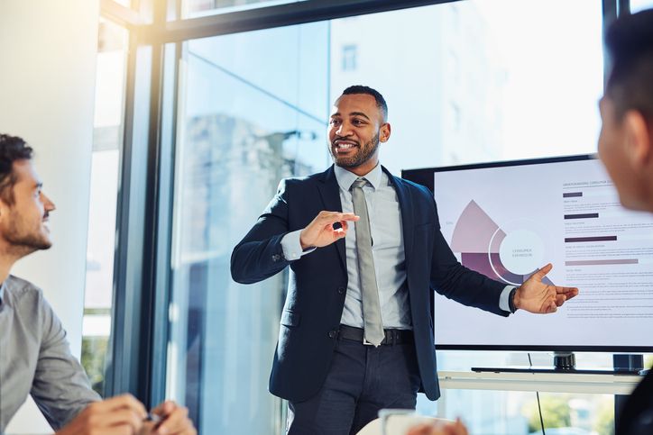 Shot of a young businessman delivering a presentation to his colleagues in the boardroom of a modern office