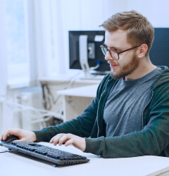 man-with-glasses-student-computer-science-class-person-uses-computer